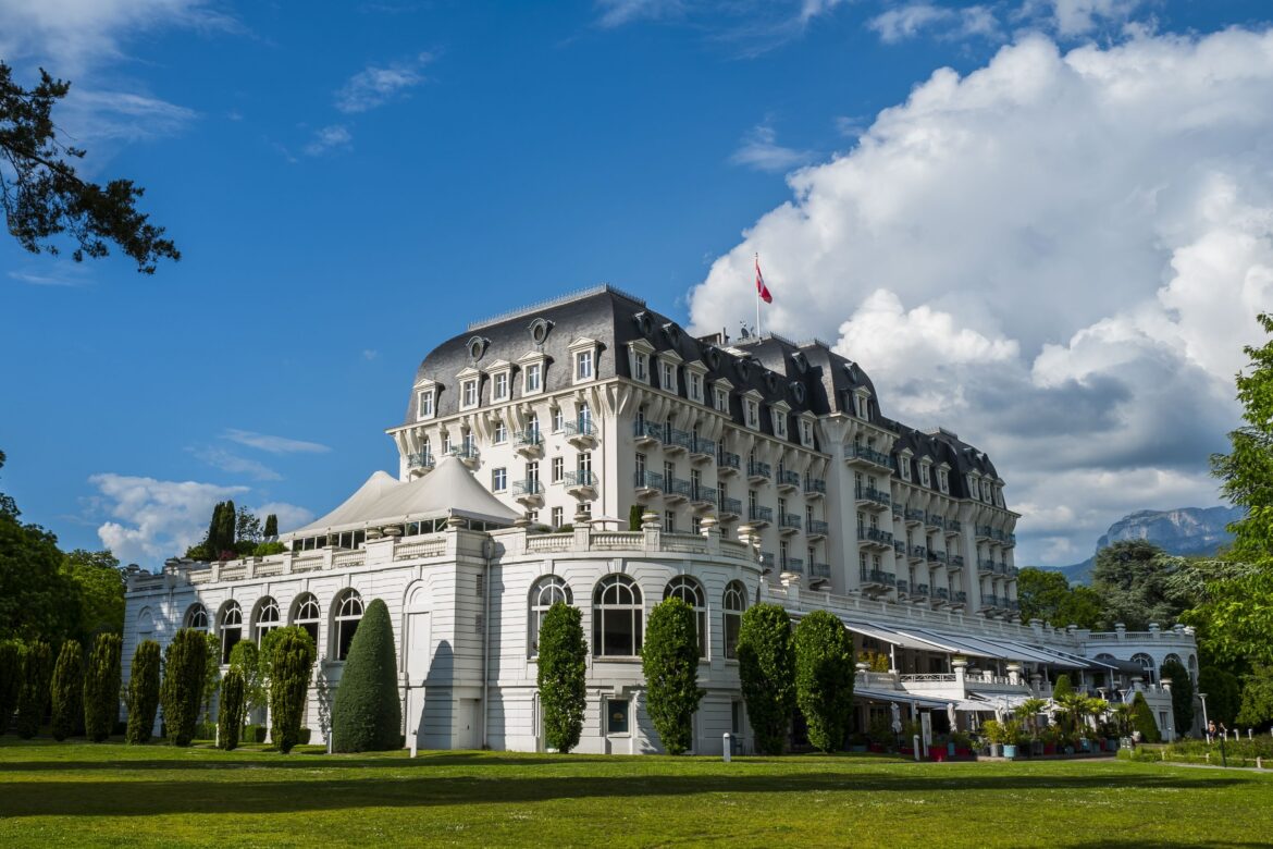 The Centre de Congrès Impérial, a Belle Époque building on the shore of Lake Annecy, with the Alps behind it